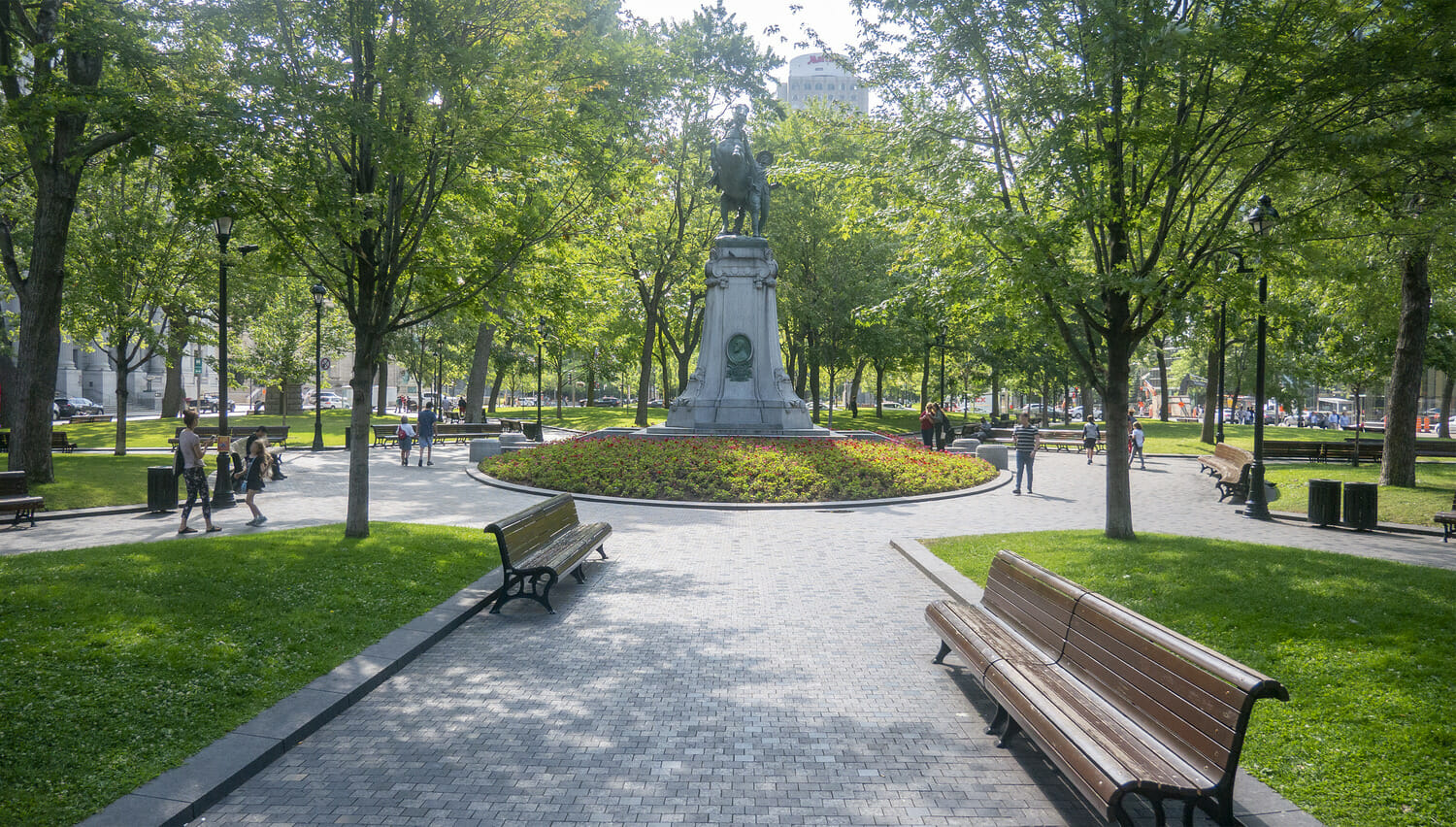 Un parc avec des bancs et une statue.