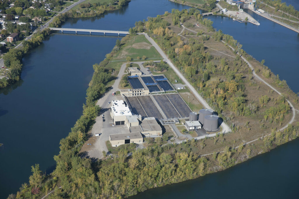An aerial view of a water treatment plant near a river.