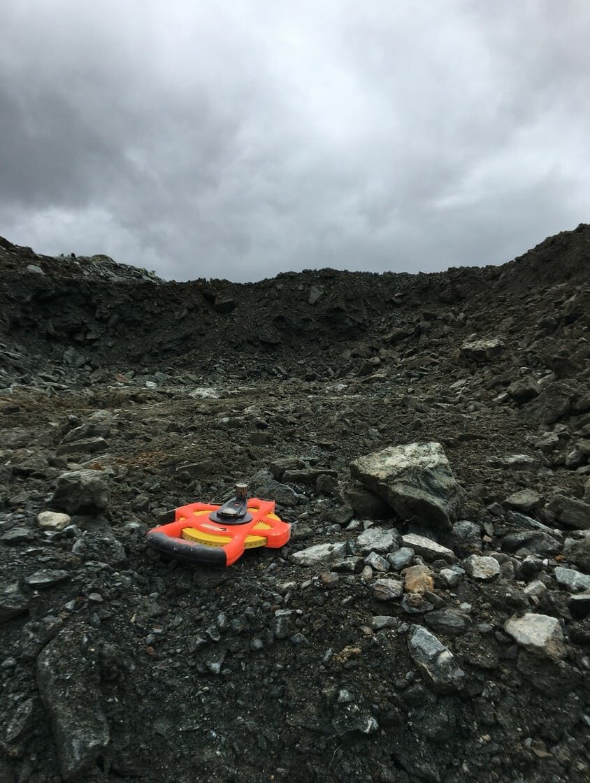 Un frisbee rouge et orange posé sur le sol.