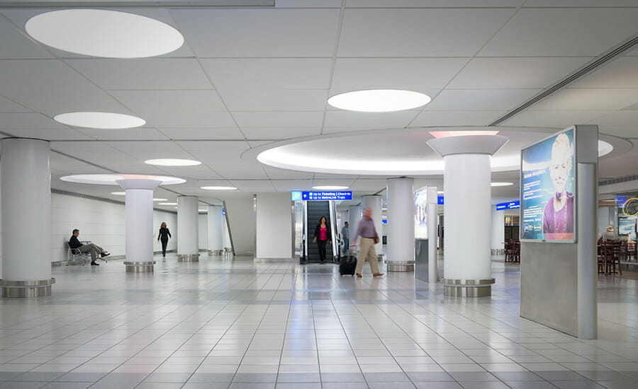 A person walking down a hallway in an airport.