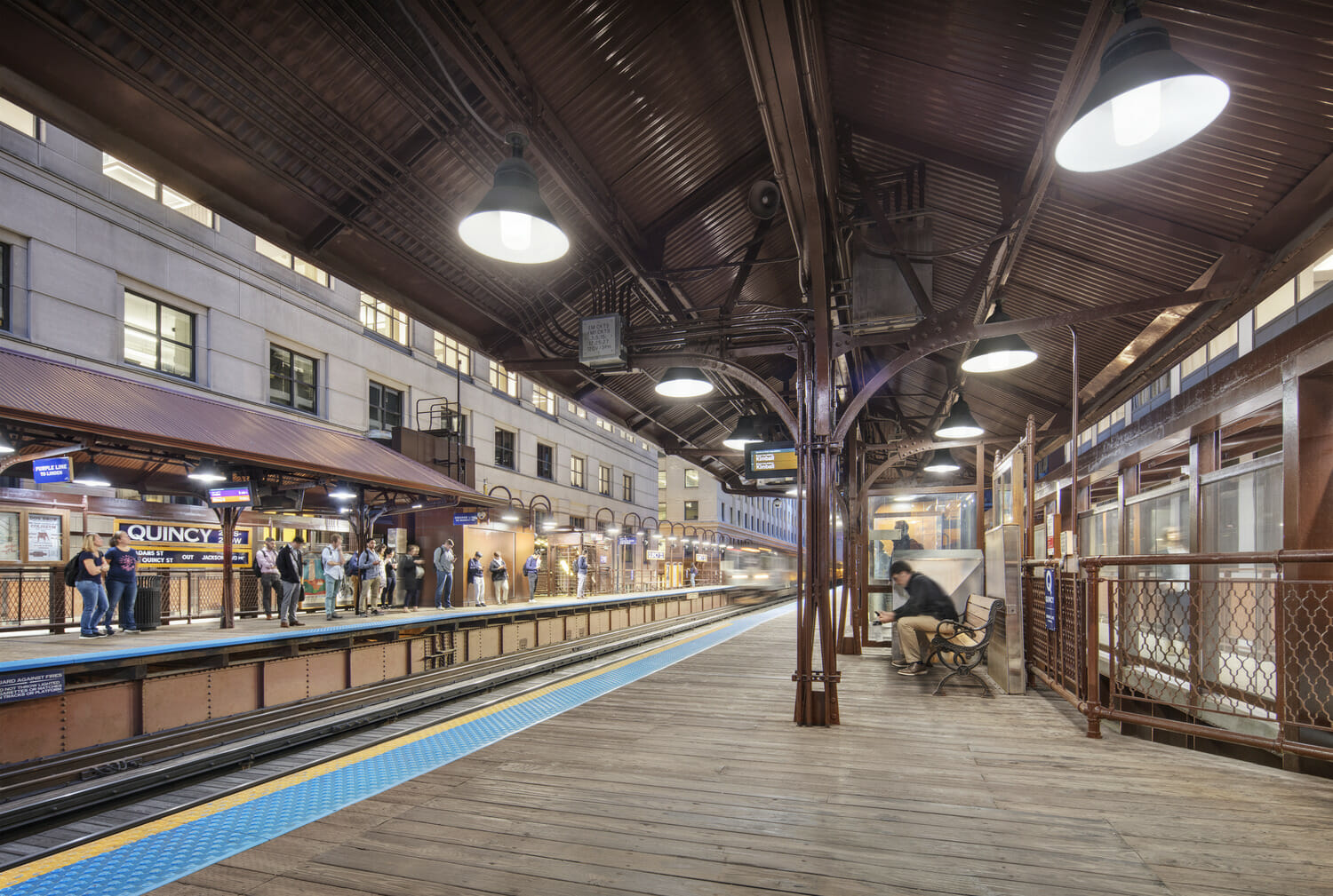 A train station with people on the platform.