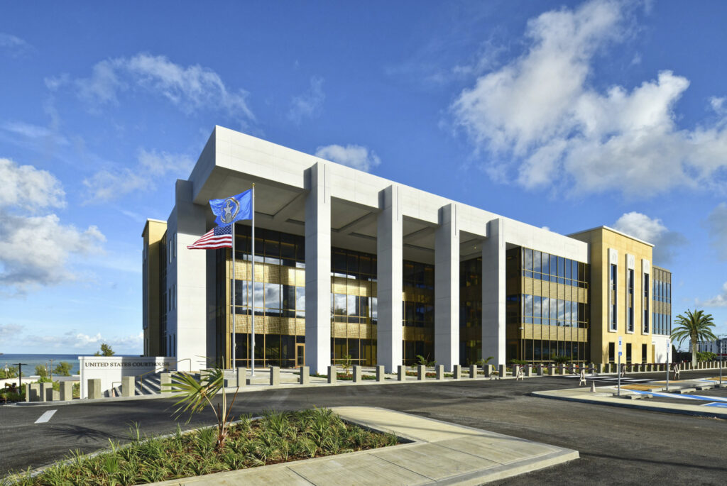 A rendering of a building with columns and a view of the ocean.