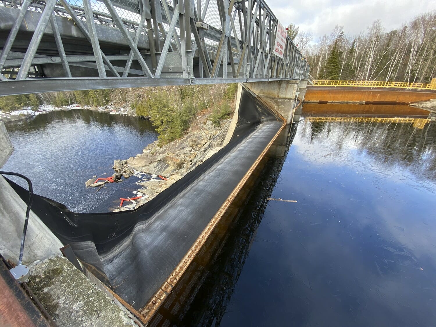 A bridge over a river with a boat on it.