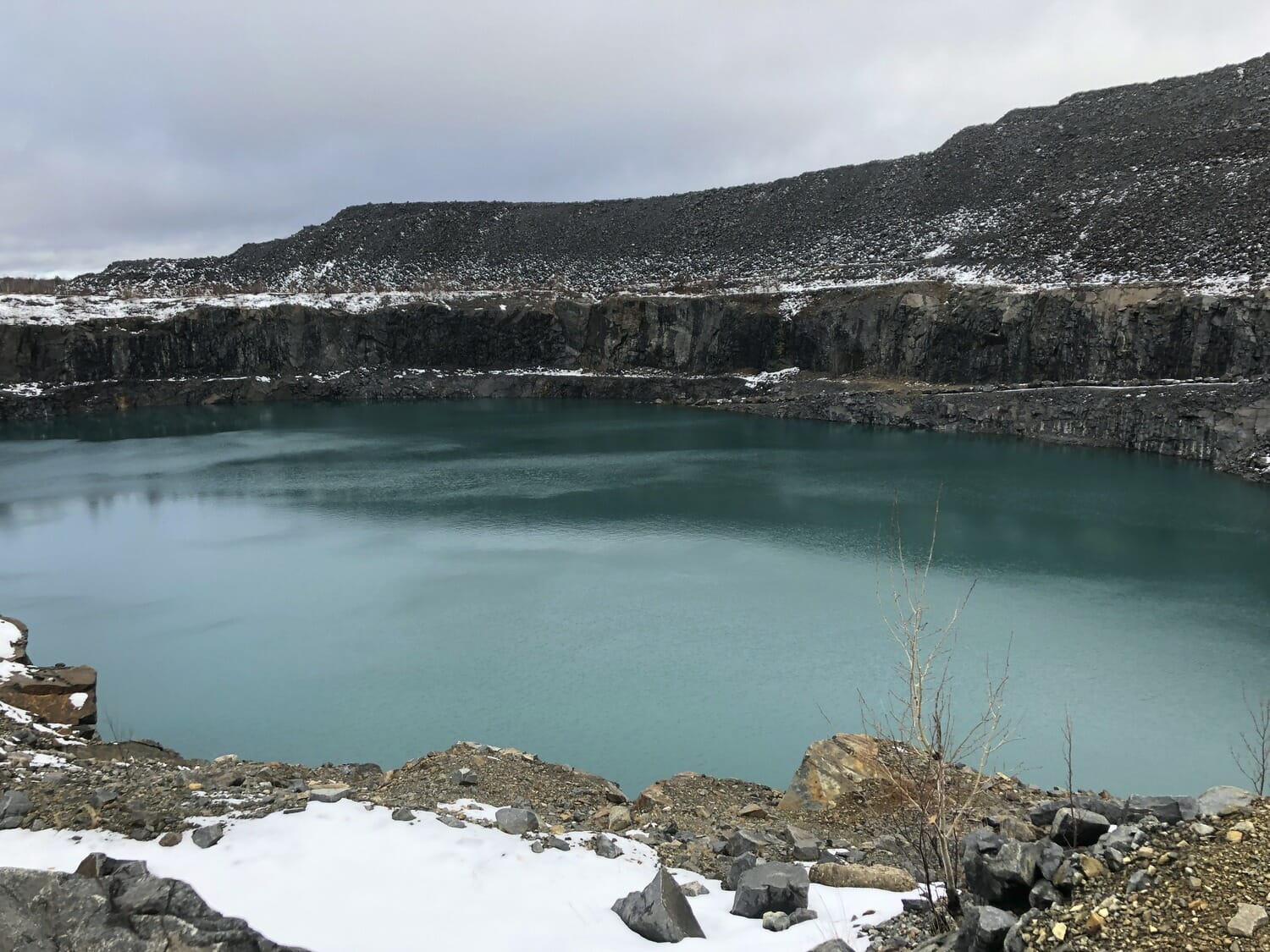 A blue lake in the middle of a rocky area.