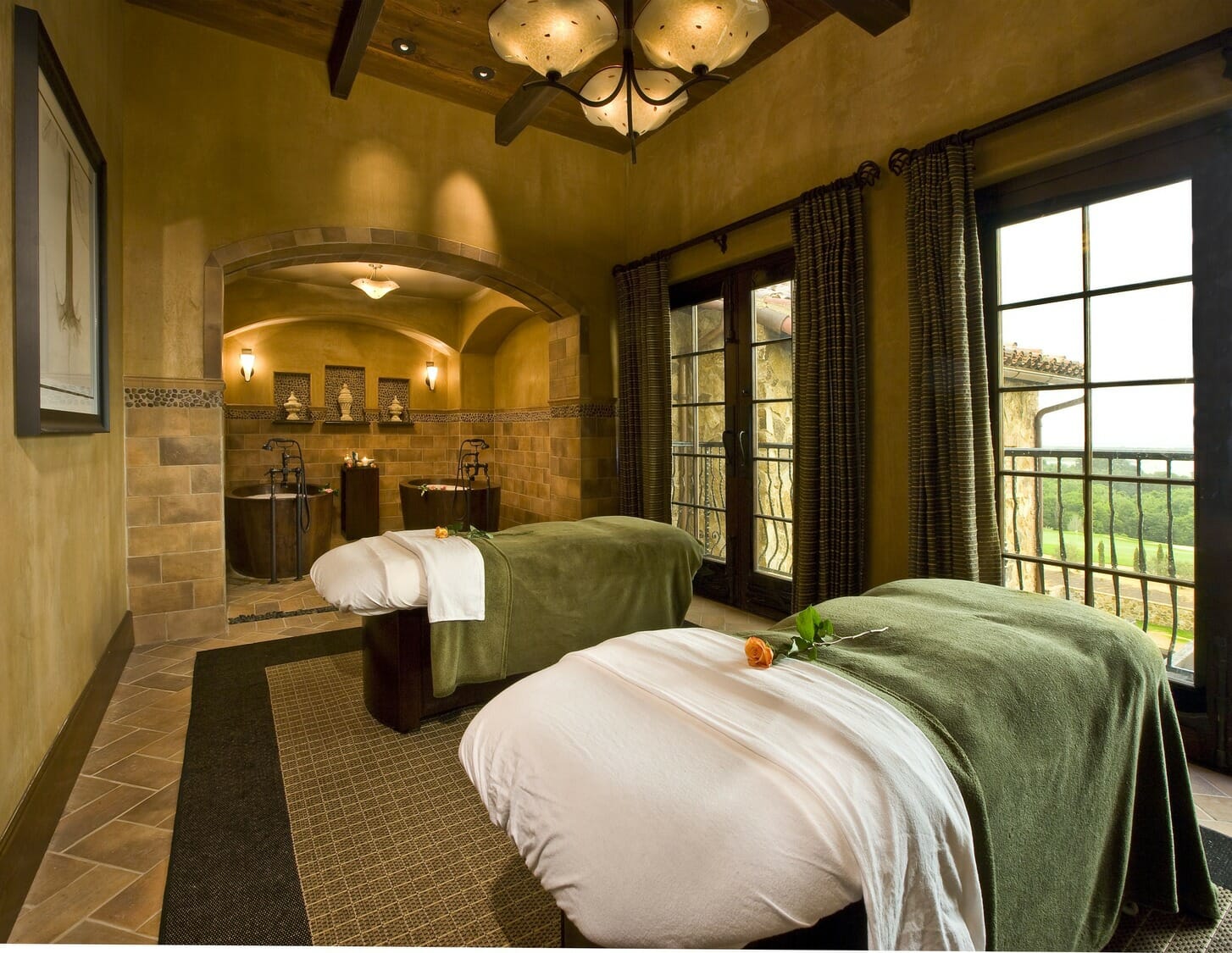 Two massage beds in a room with a large window.