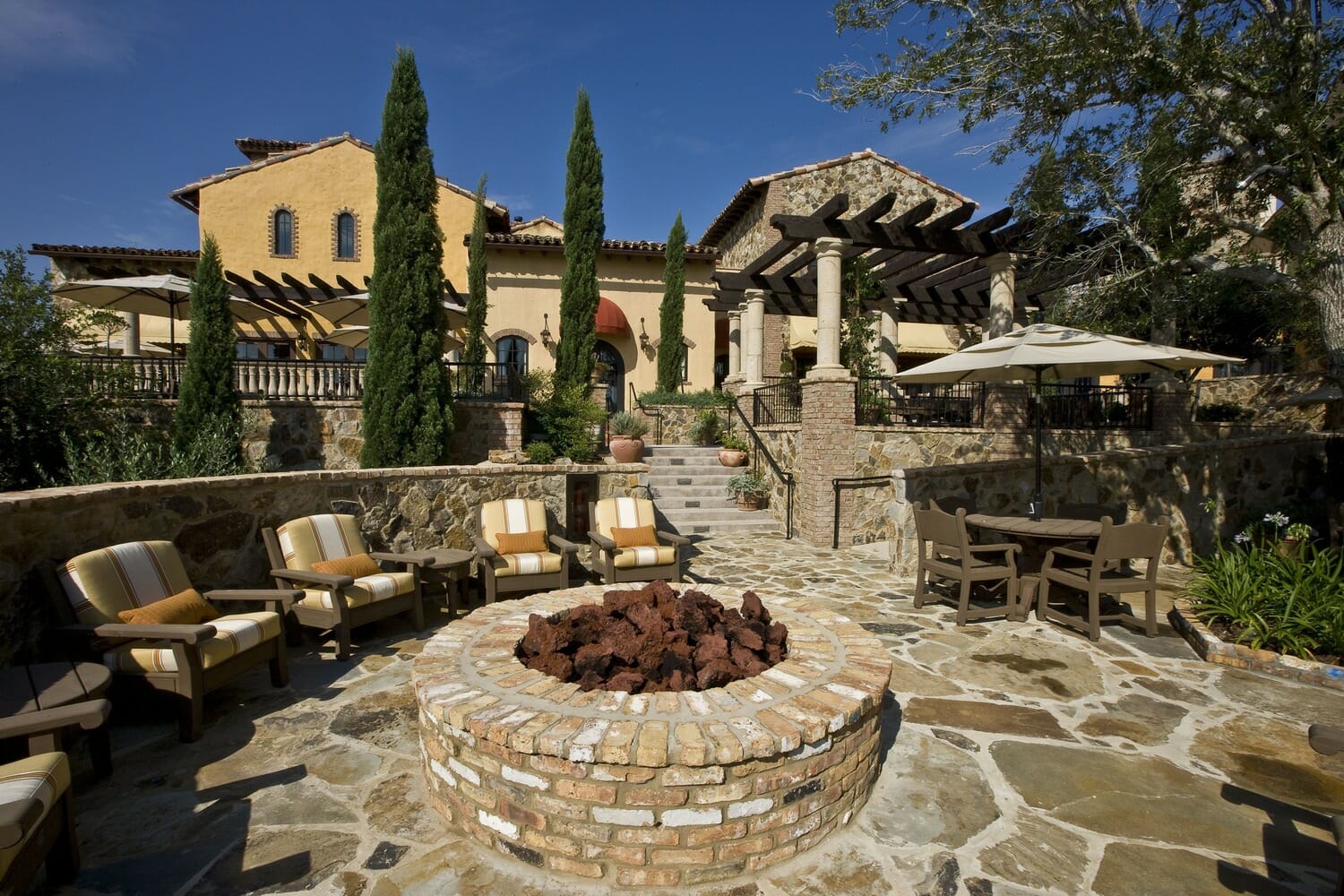 A stone fire pit in the backyard of a home.