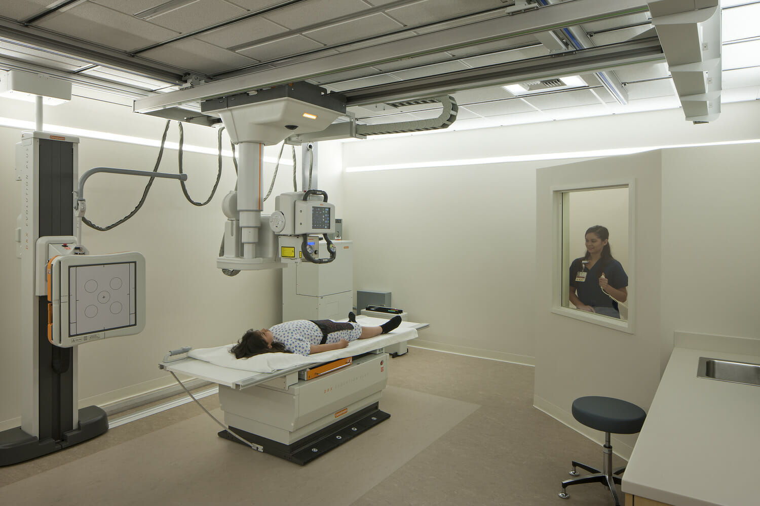 A person laying on a bed in a medical room.
