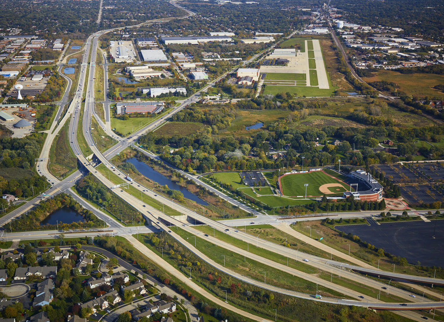 An aerial view of a highway and a baseball field.