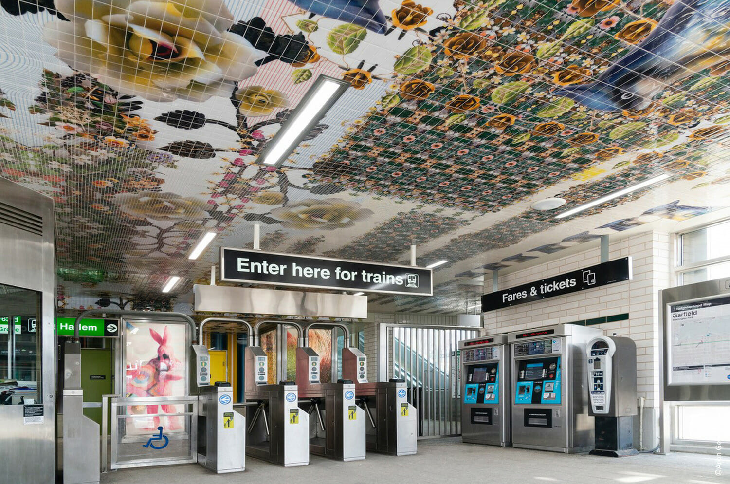 A subway station with a mural on the ceiling.