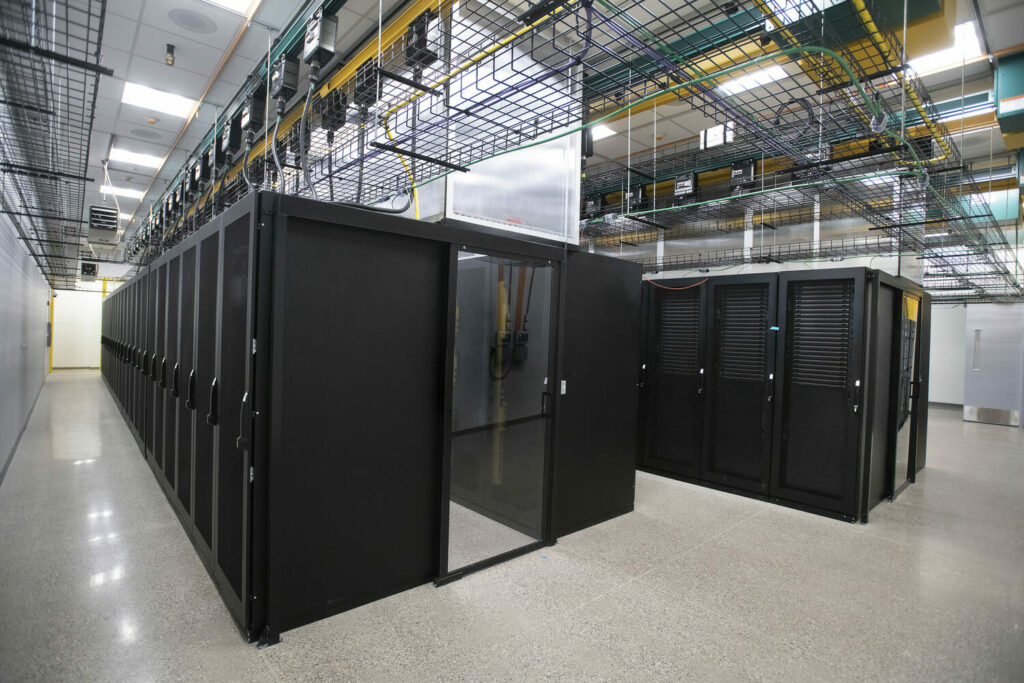 A large data center with black cabinets and doors.