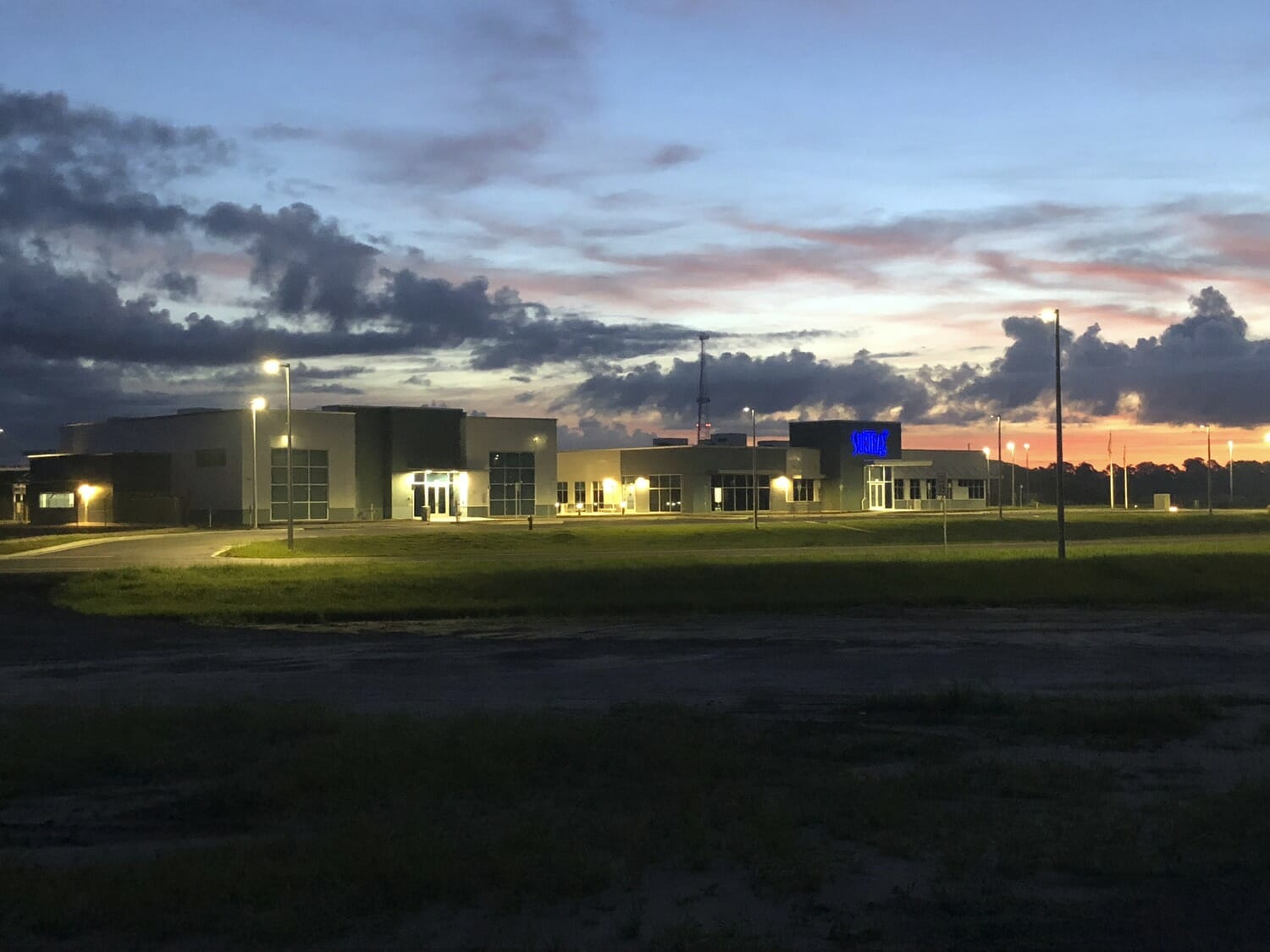 Un bâtiment au crépuscule devant un champ.