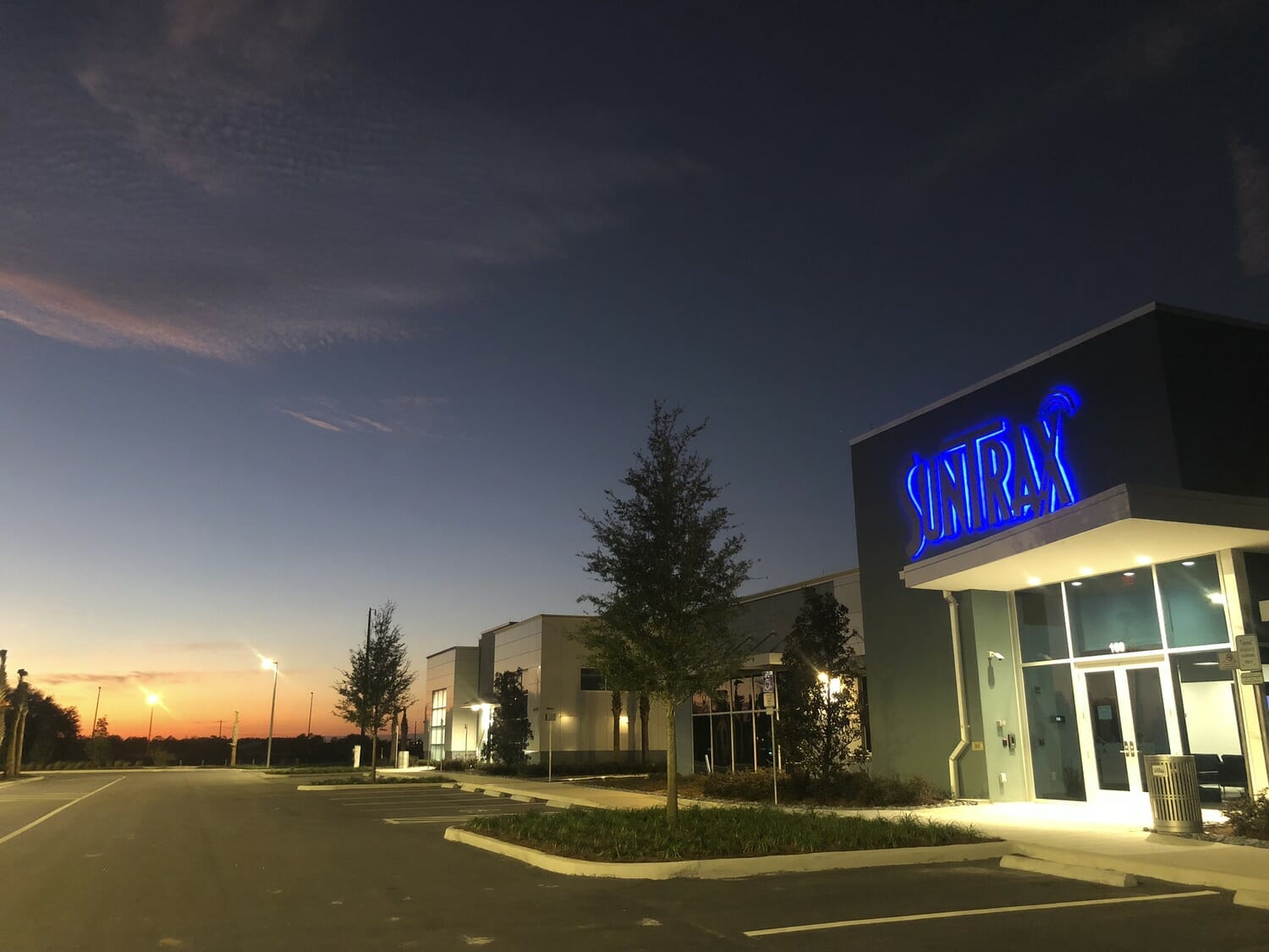 A building with a blue sign at dusk.