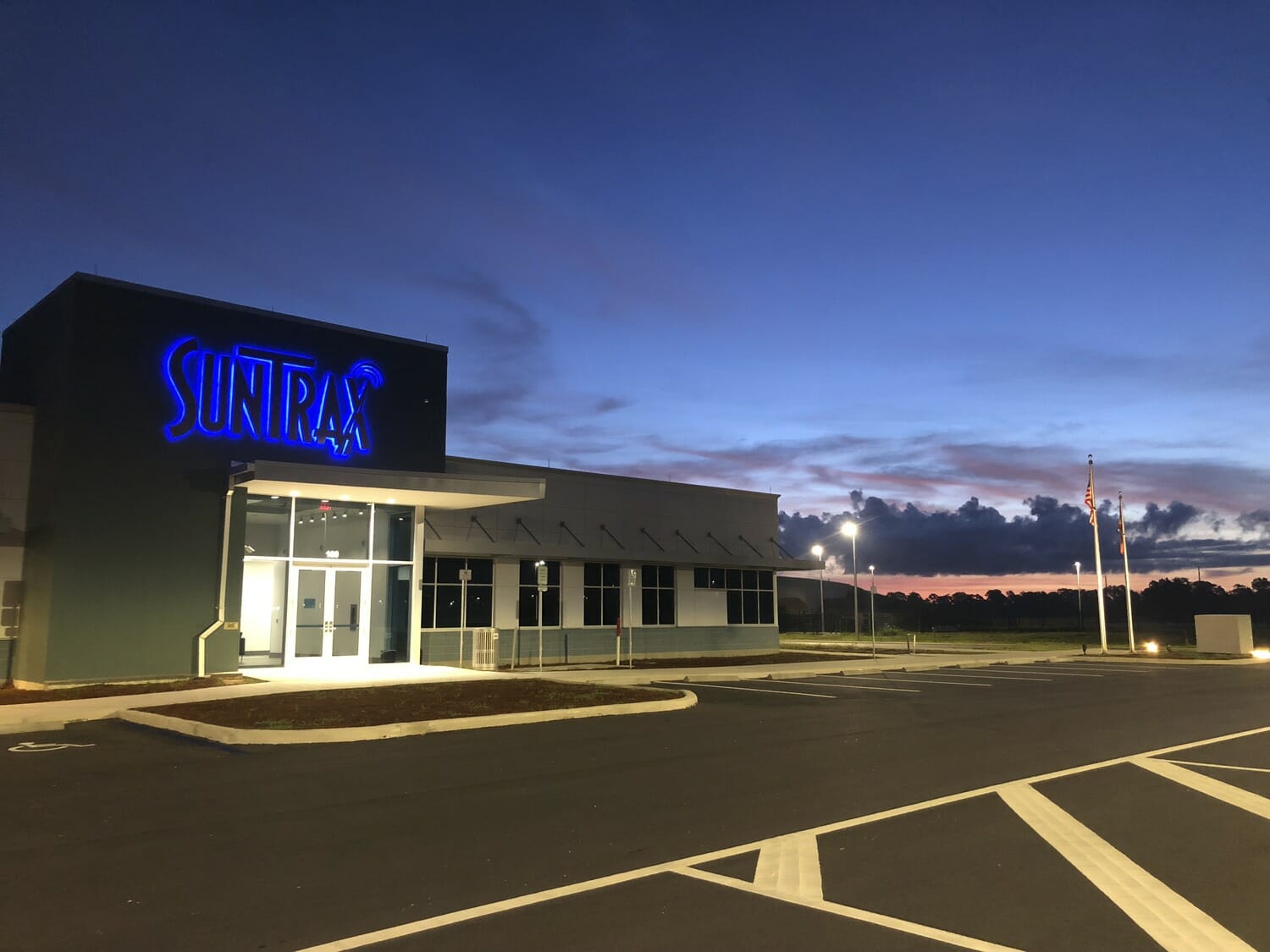 A building with a blue sign at dusk.