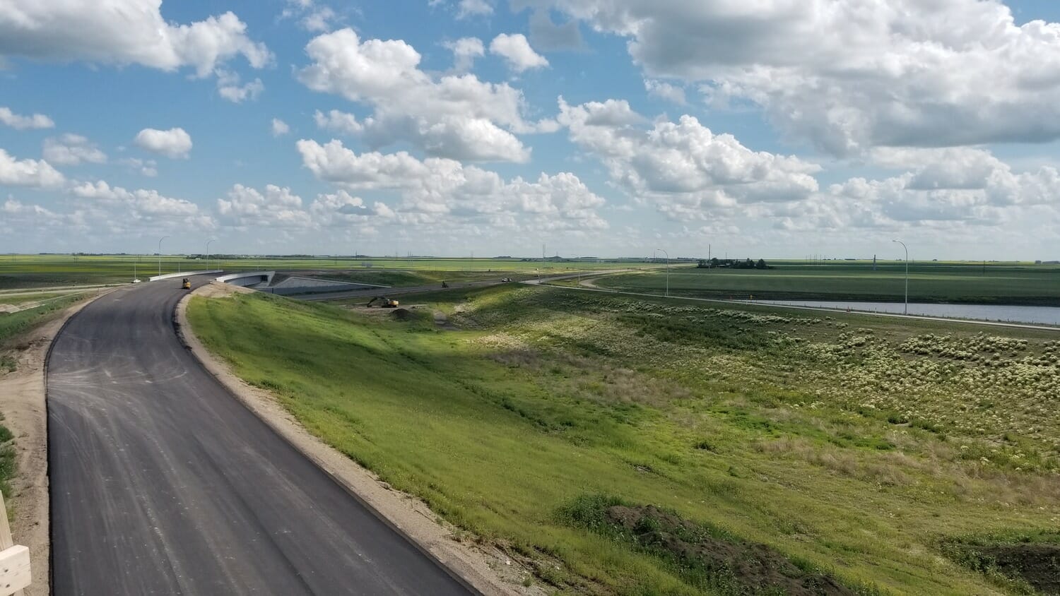 An aerial view of a highway in the middle of a field.