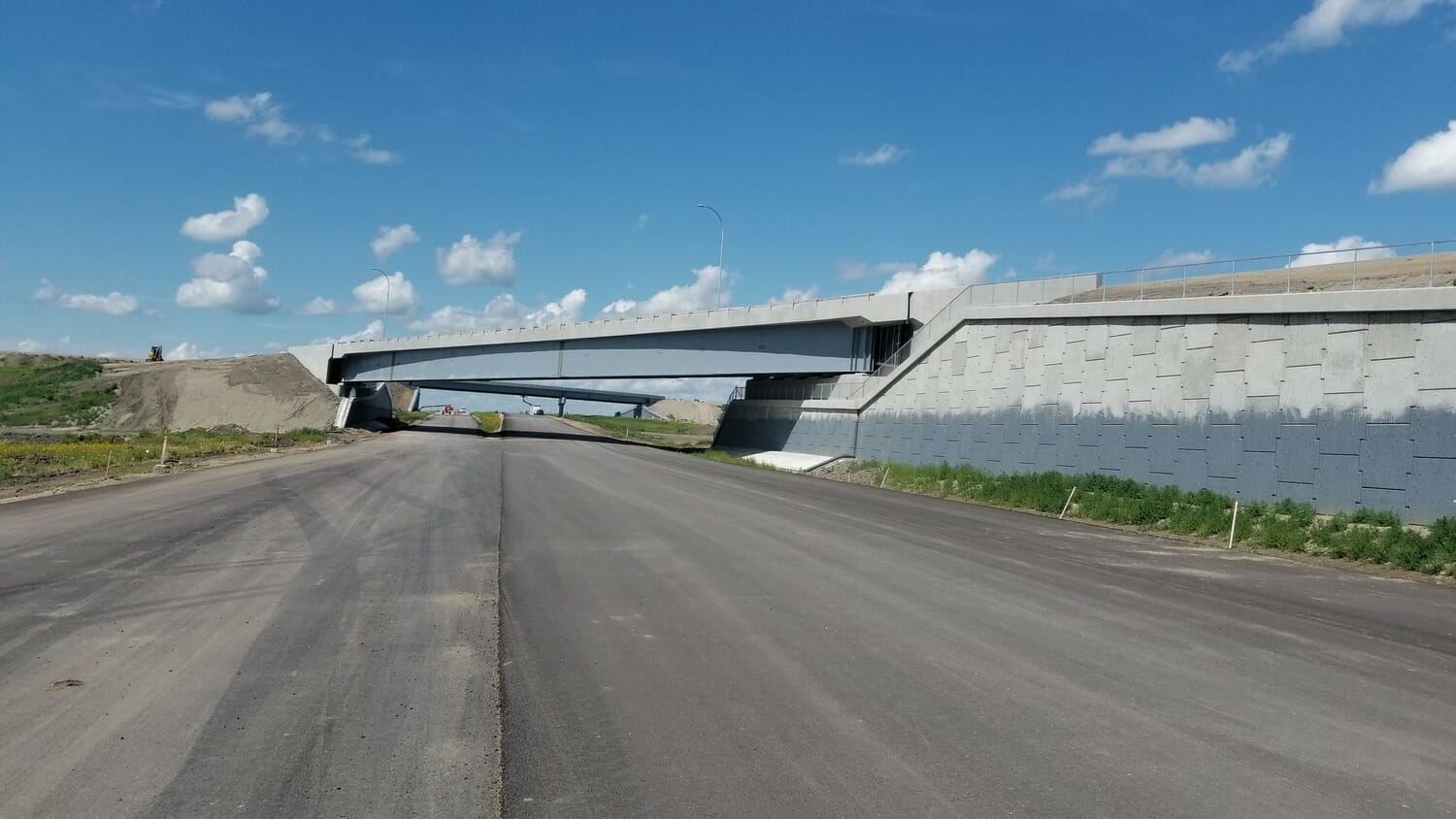 An empty road with a bridge over it.