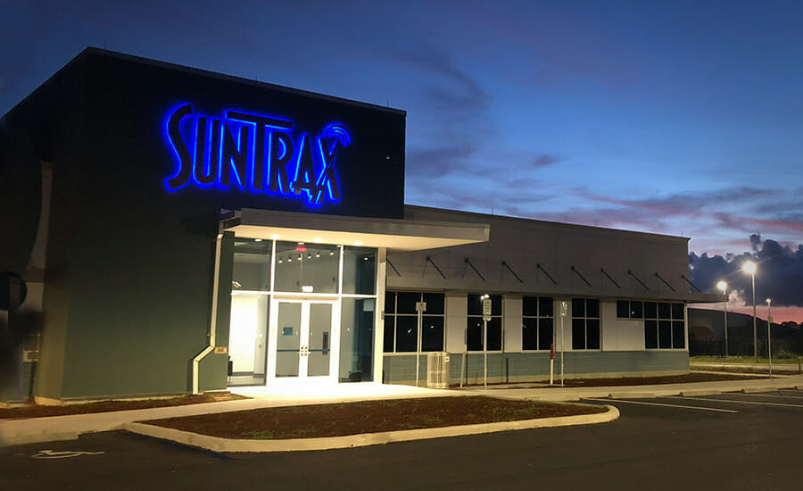 A building with a sign that says sunra at dusk.