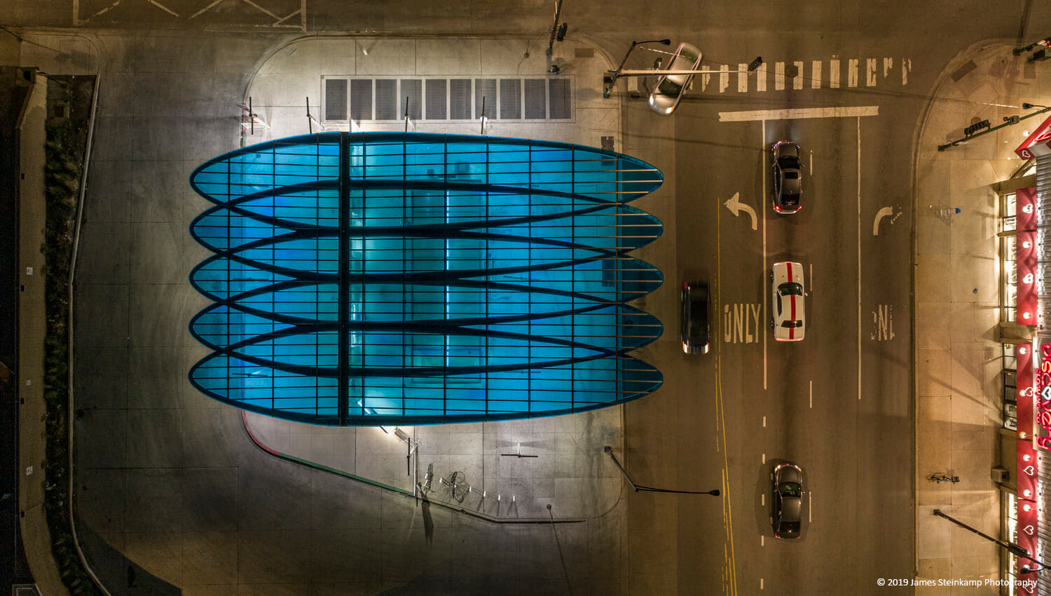 An aerial view of a blue building at night.