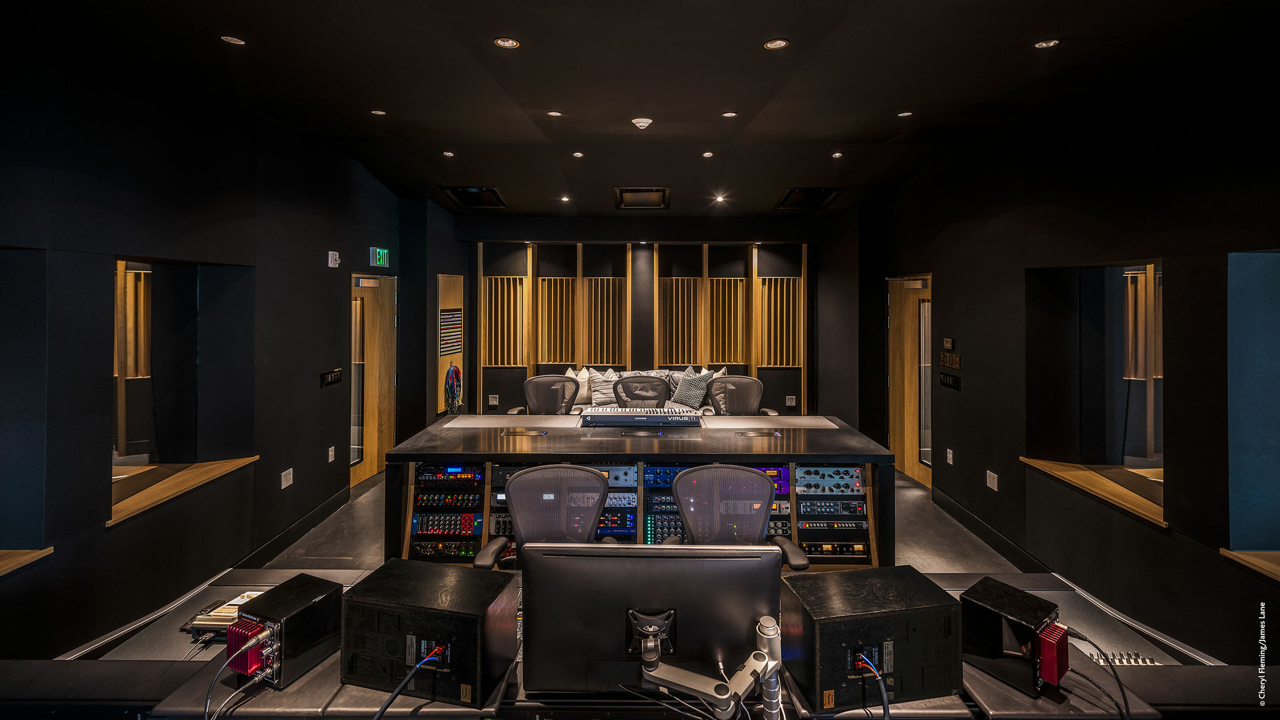 Un studio d'enregistrement avec un bureau et des chaises.