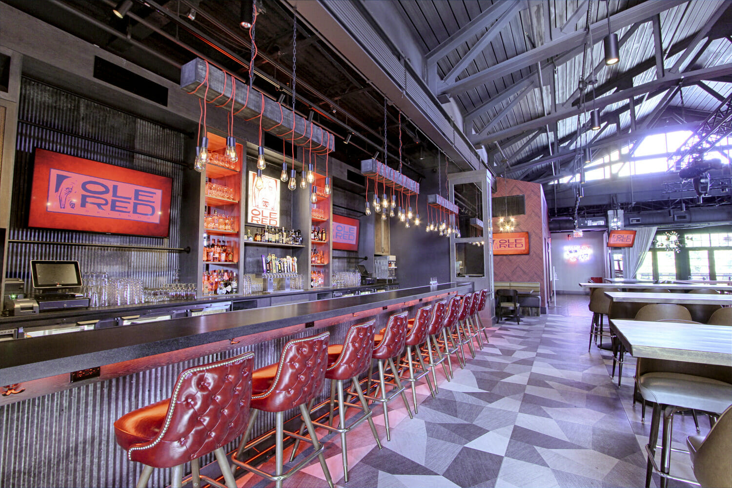 L'intérieur d'un restaurant avec des chaises rouges et un bar.