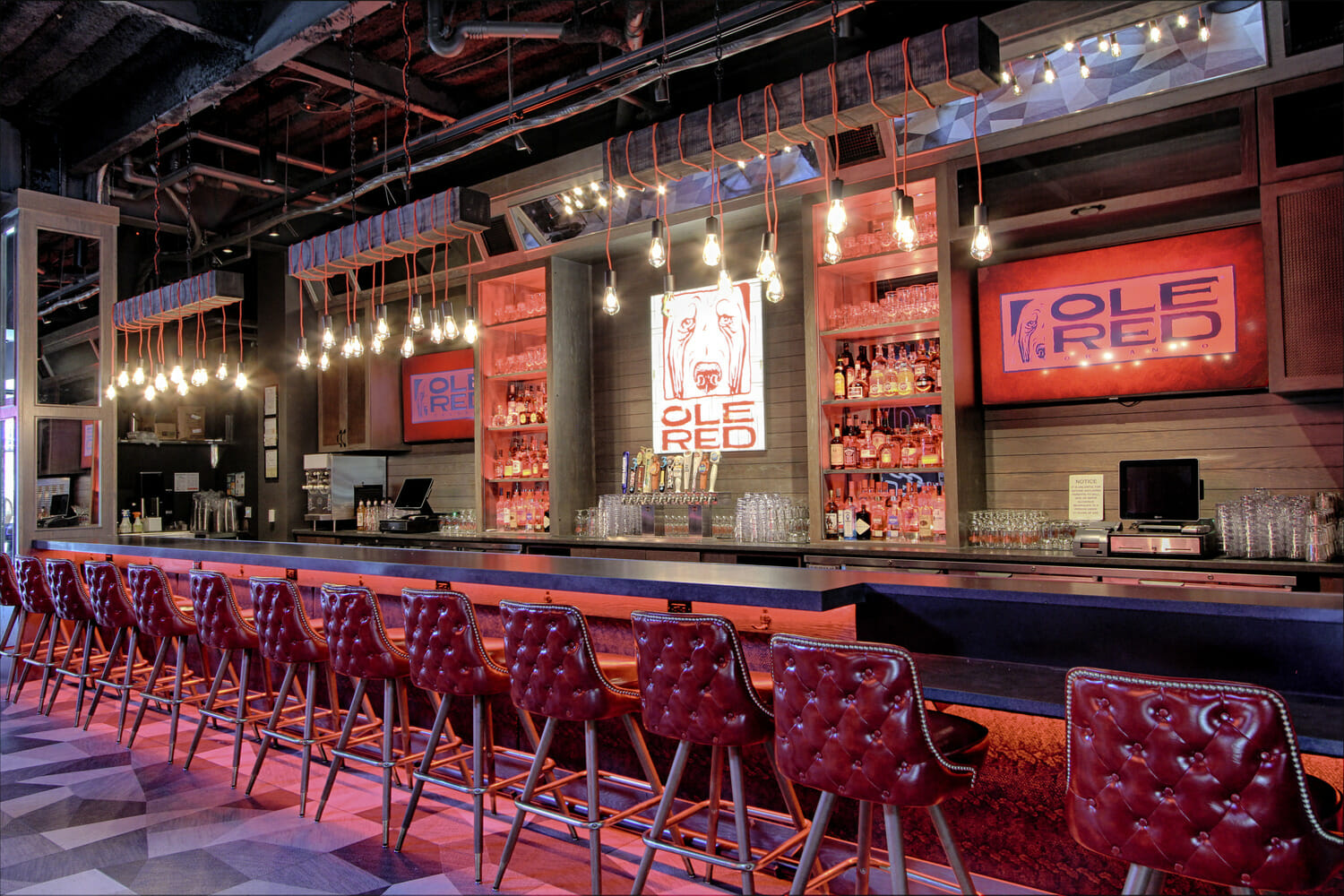 A bar with red chairs.