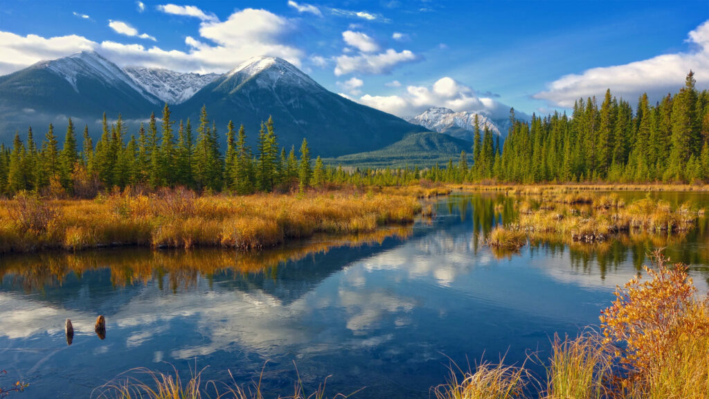 The mountains are reflected in the water of a river.