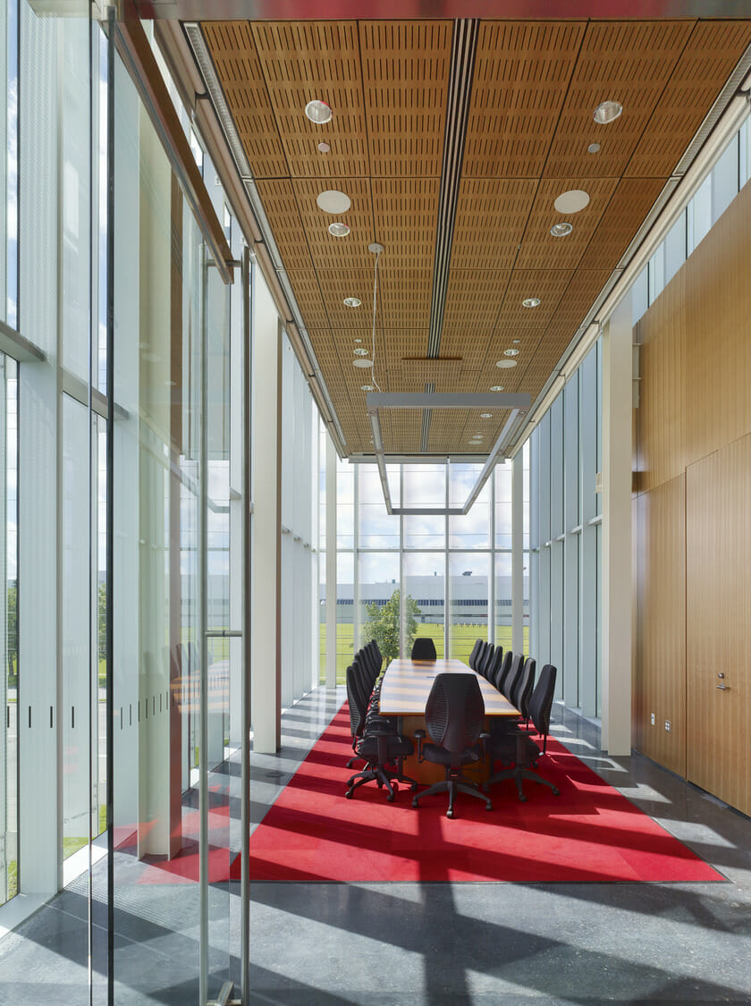 A conference room with glass walls and a red carpet.