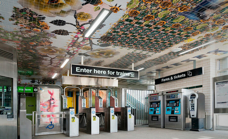 A subway station with a tiled ceiling.
