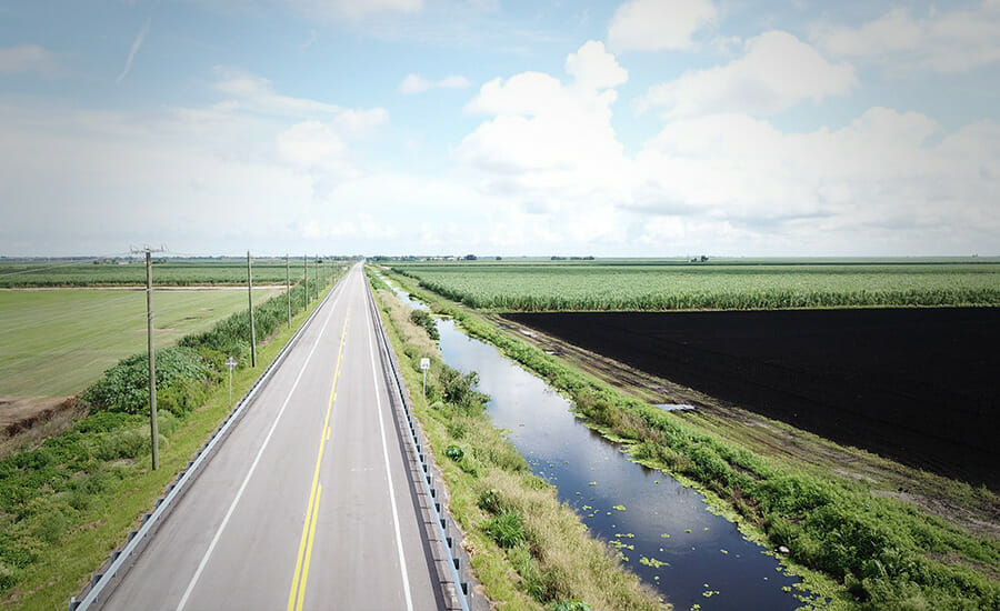 An aerial view of an empty road in a field.