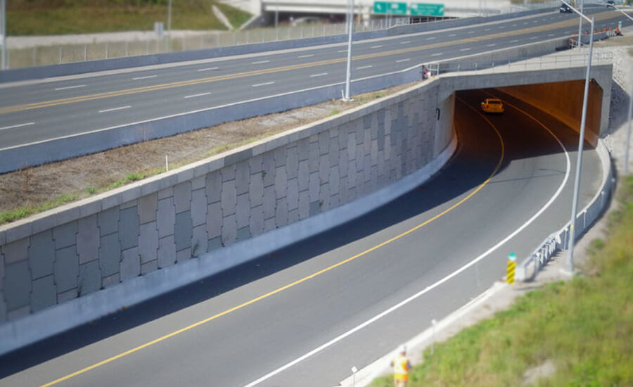 A car is driving down a highway through a tunnel.