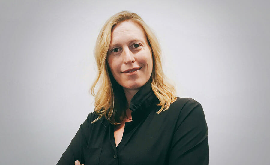 A woman in a black shirt with her arms crossed.