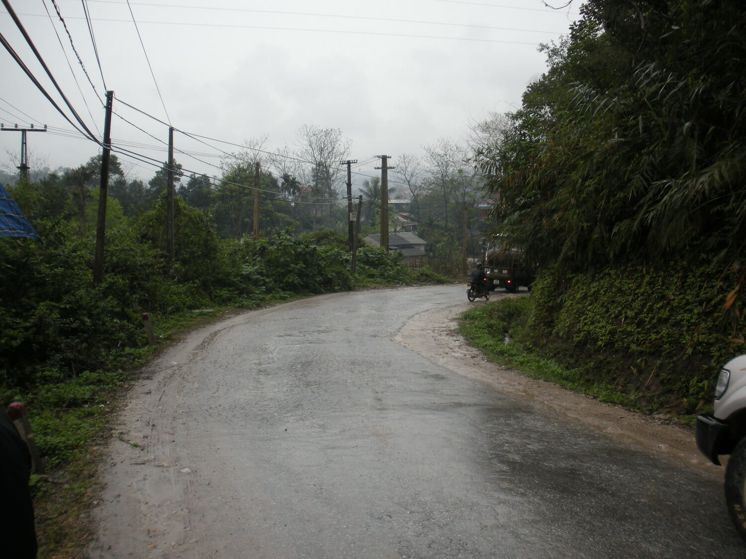 A car is parked on a wet road.