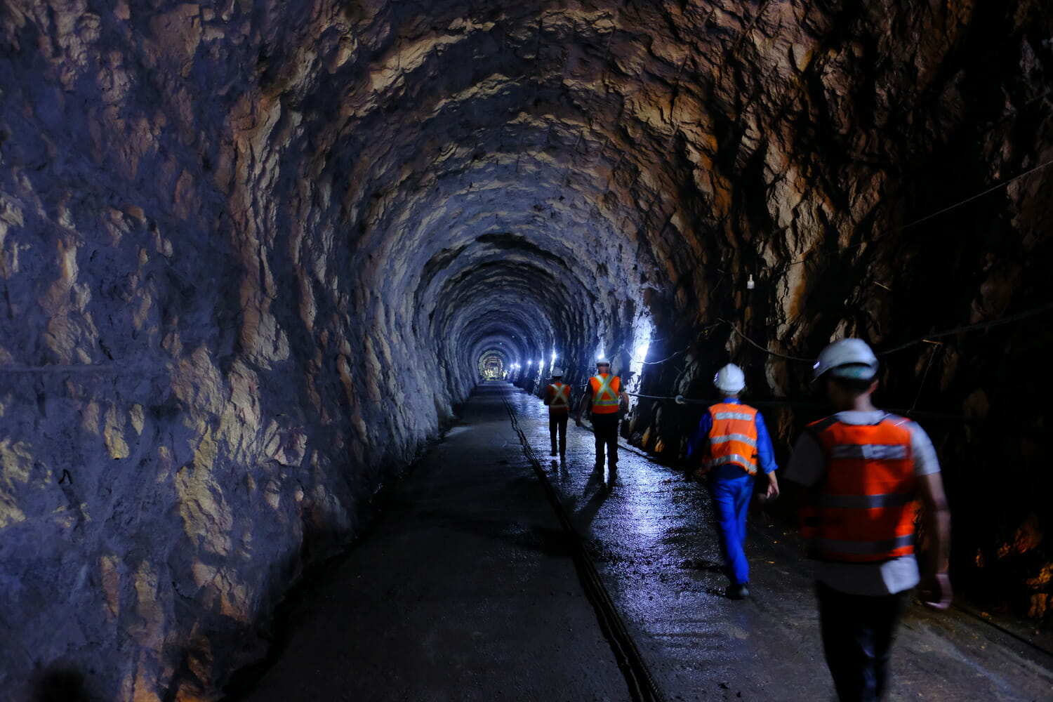 A group of workers walking through a tunnel.