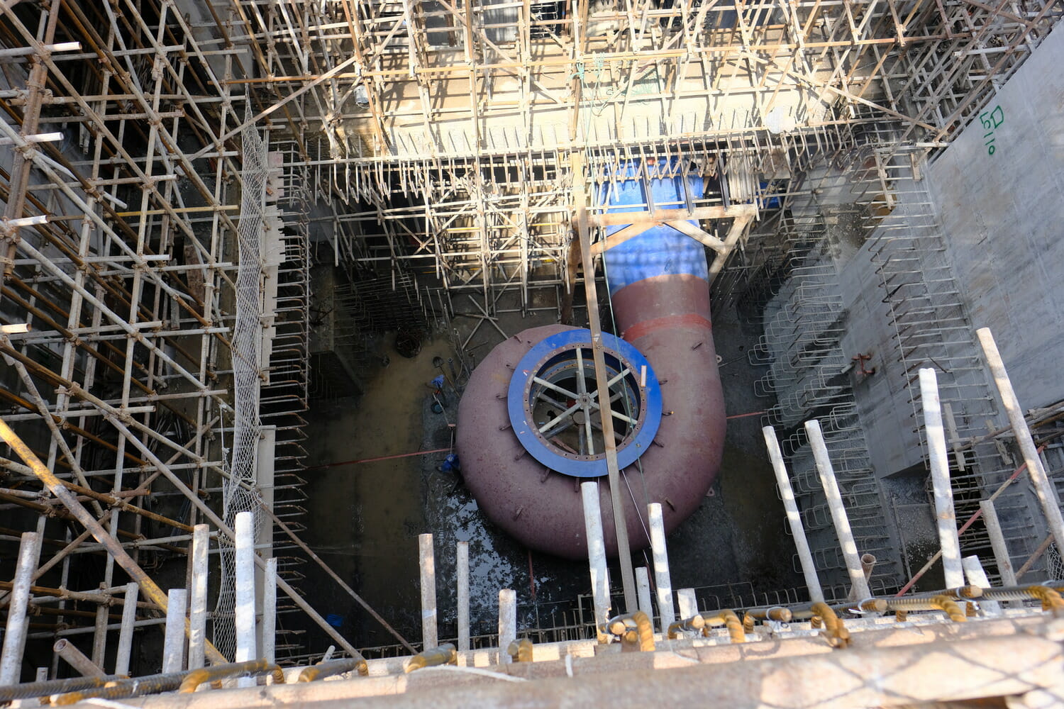 A large pipe is under construction in a building.