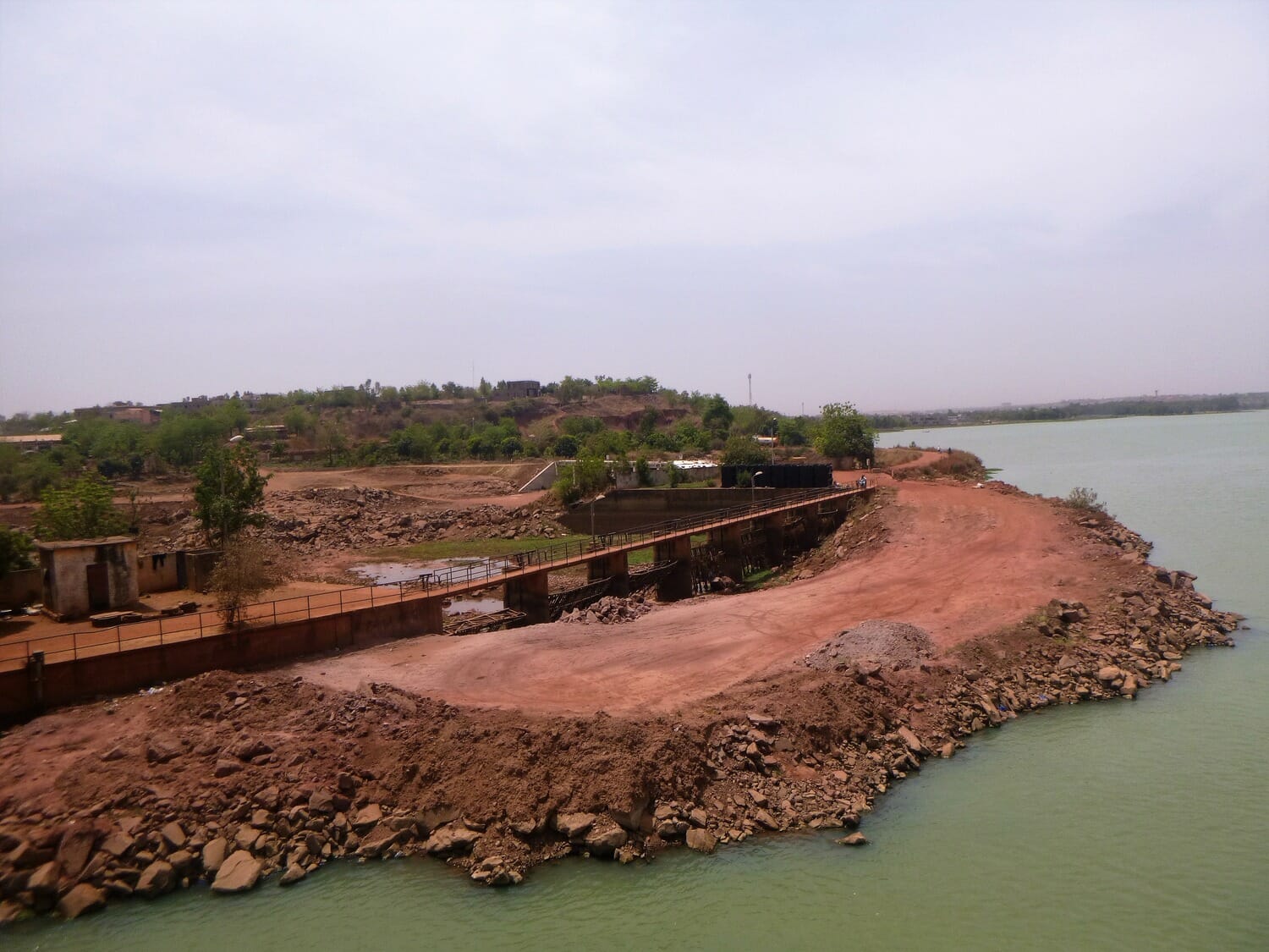 An aerial view of a river and a dirt road.