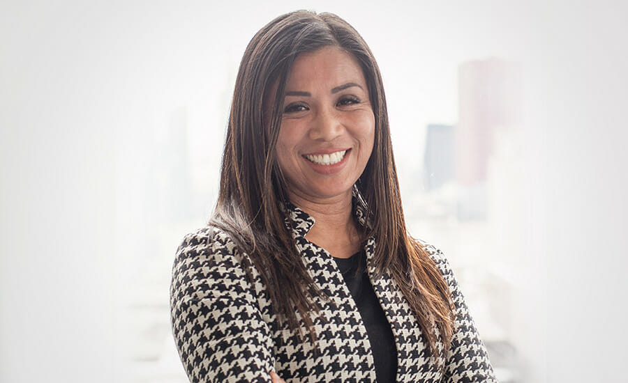 A smiling woman in a houndstooth jacket.