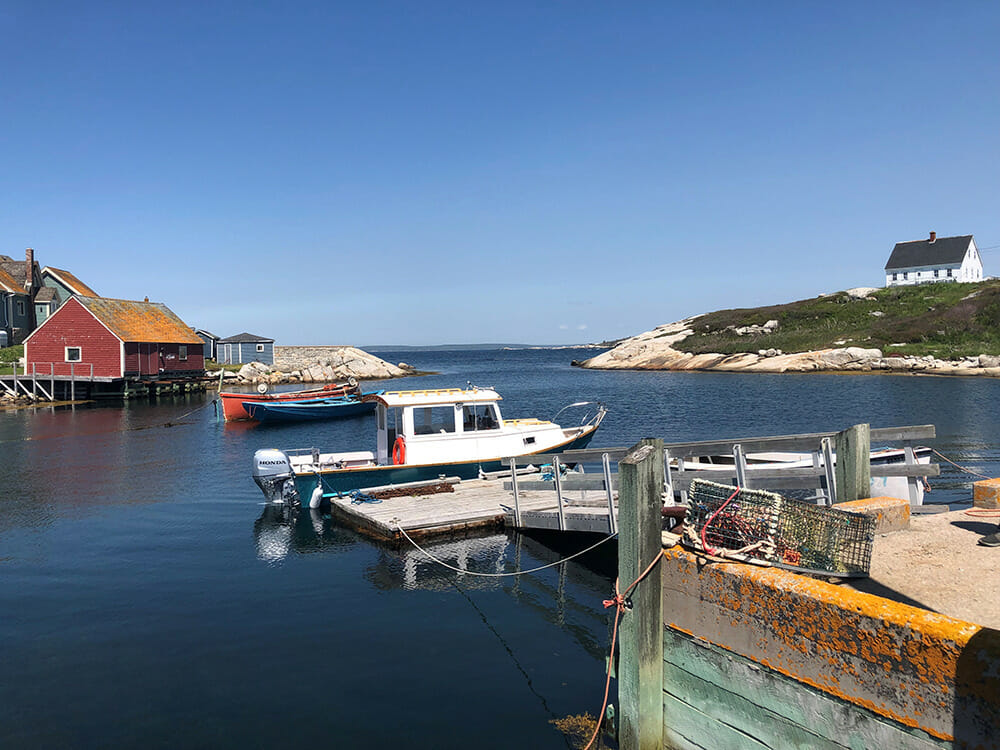 Two boats docked in the water near a house.