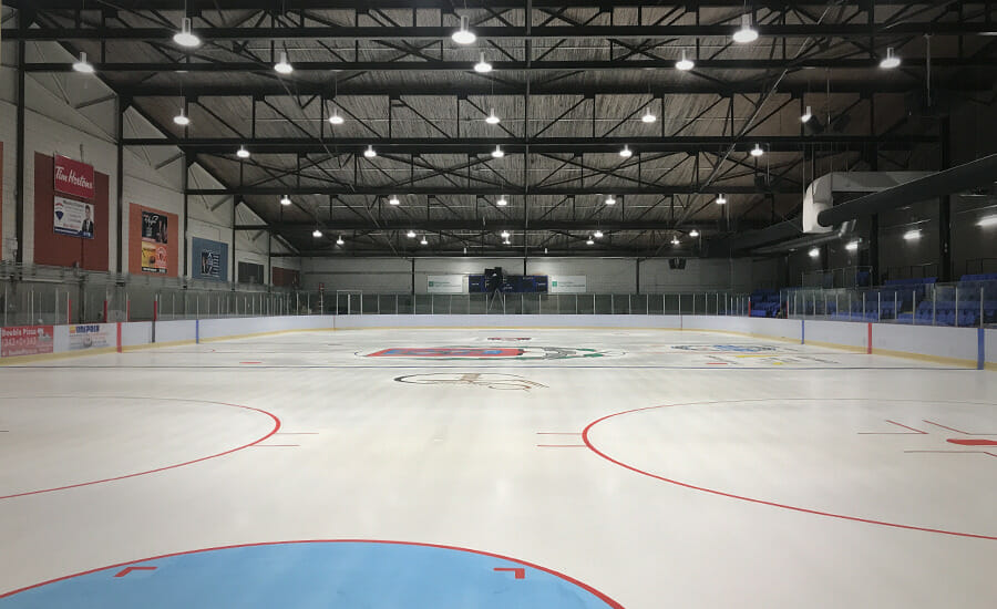 An indoor ice rink with lights on it.