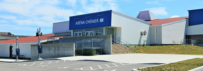 A blue and white building with a parking lot.