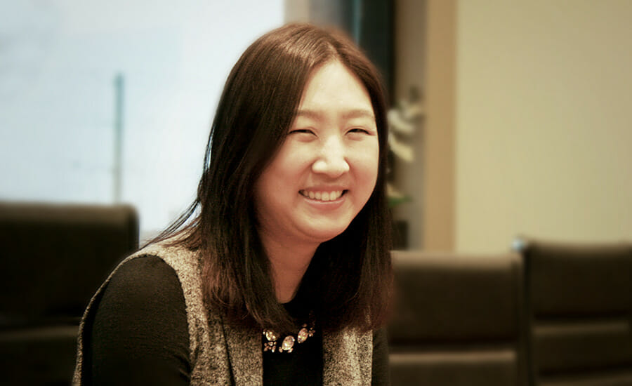 Une femme assise à un bureau en souriant.