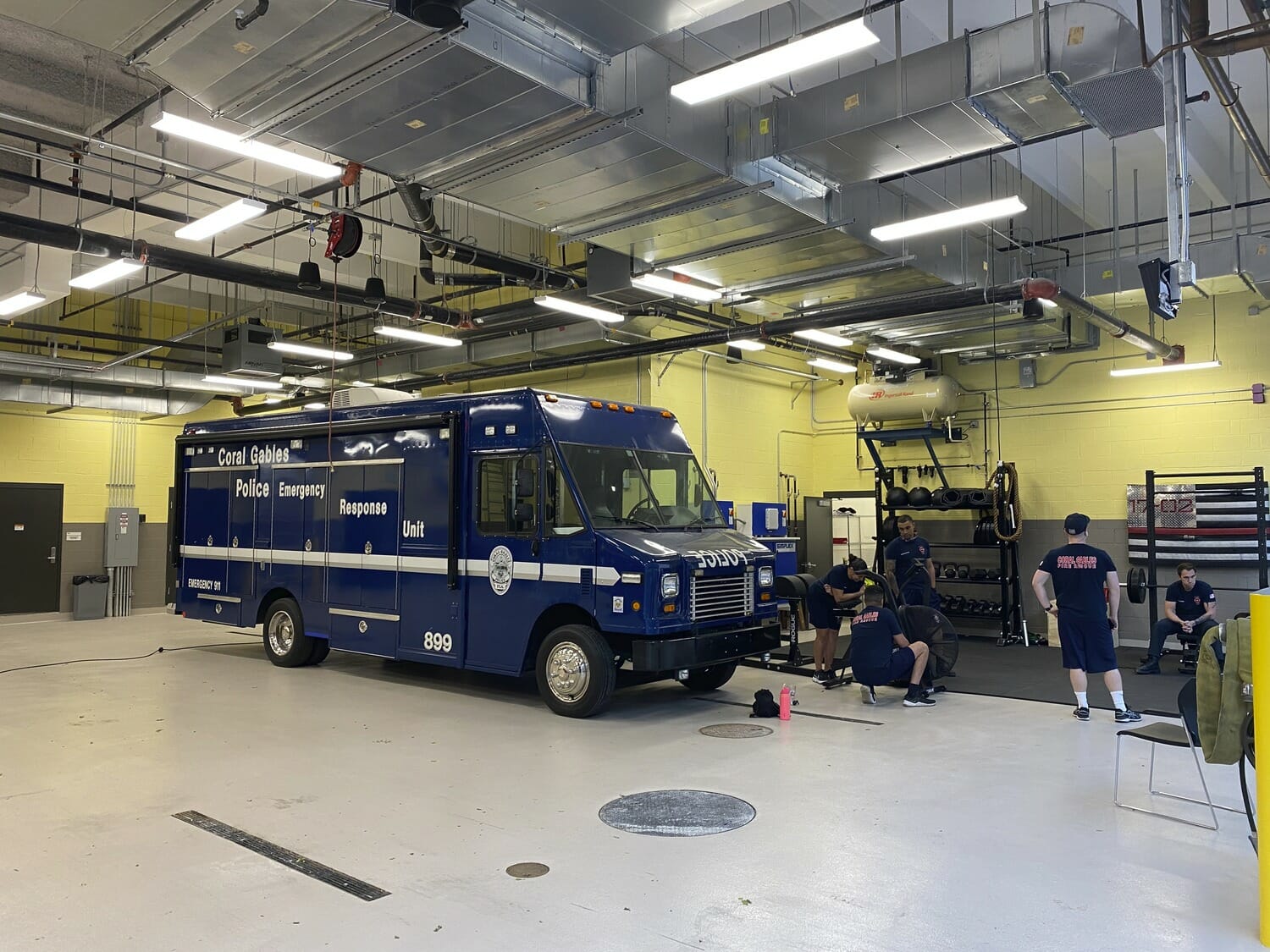 A blue ambulance parked in a large room.