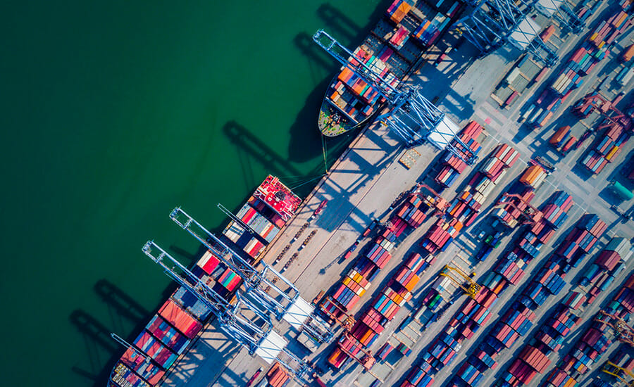An aerial view of a container ship docked in a port.