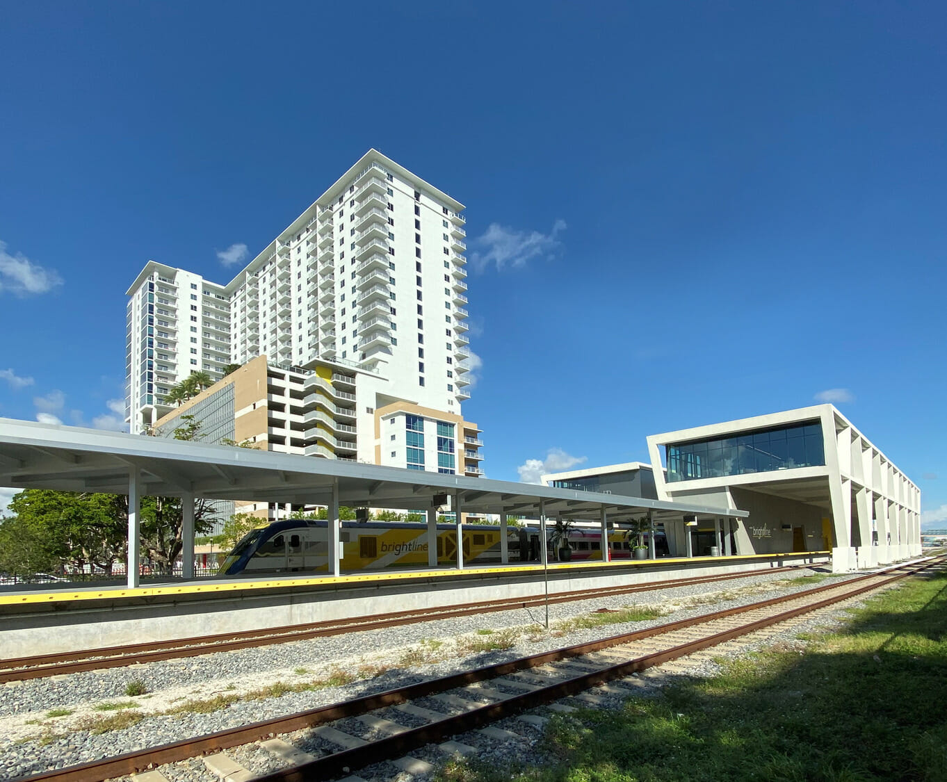 A train station with a tall building in the background.
