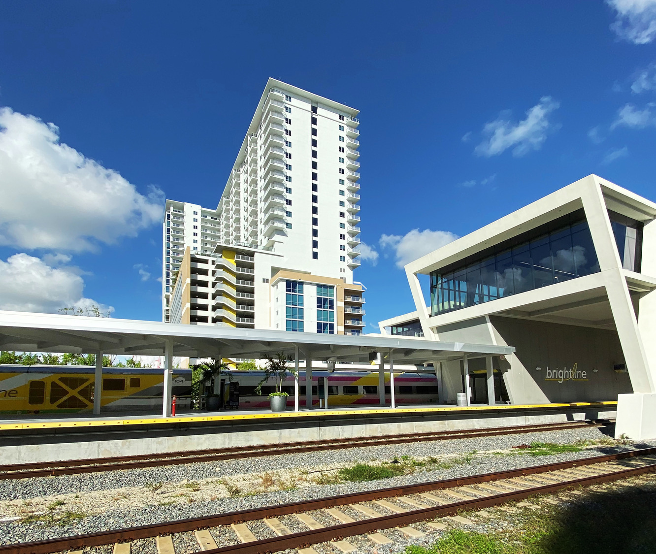 A train station with a tall building in the background.