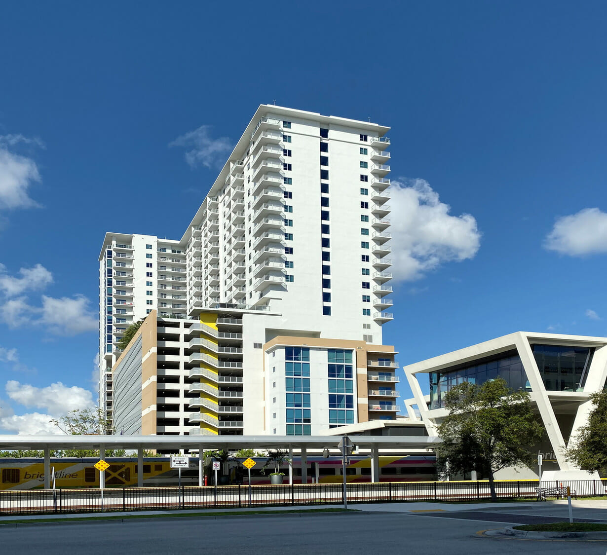 A tall building with a bus stop in front of it.