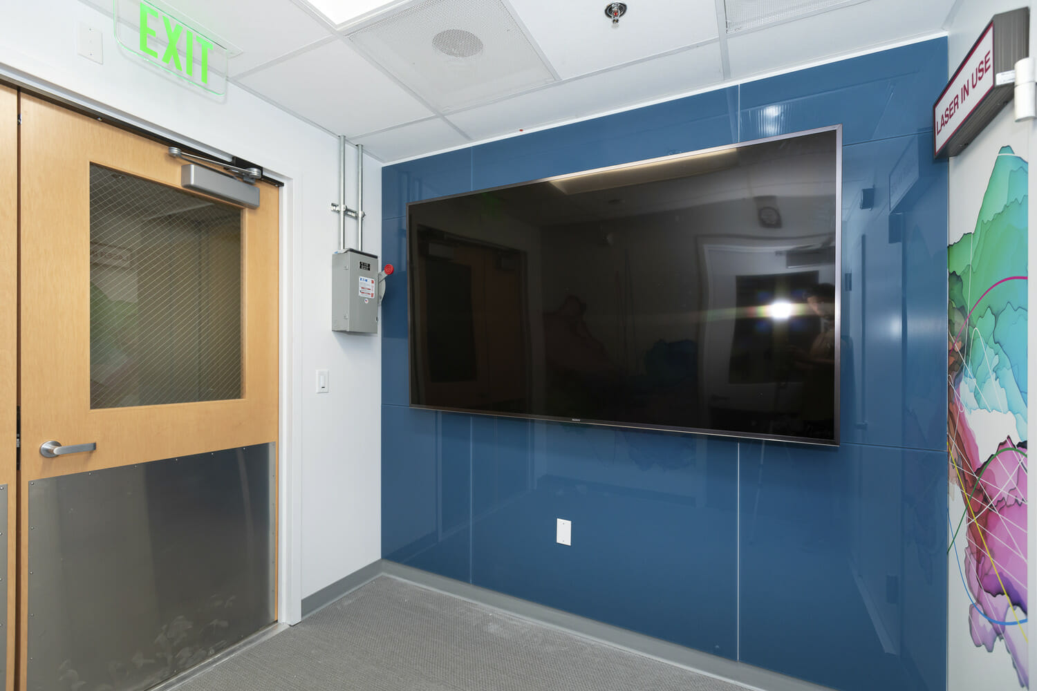 A hallway with a tv and a door.