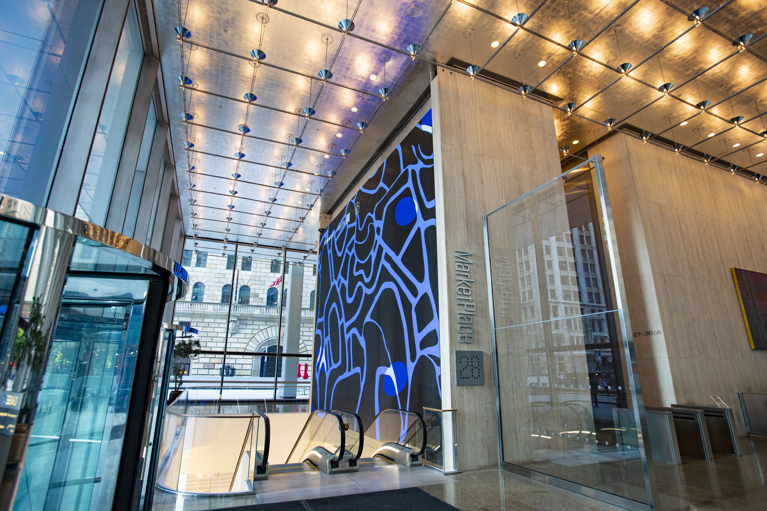 A lobby with a large glass wall and a glass door.