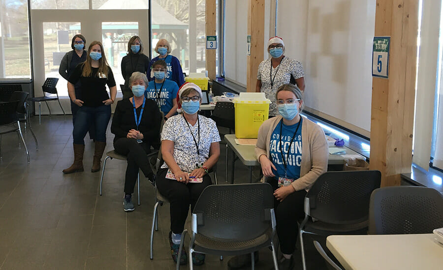 A group of people wearing face masks in a room.