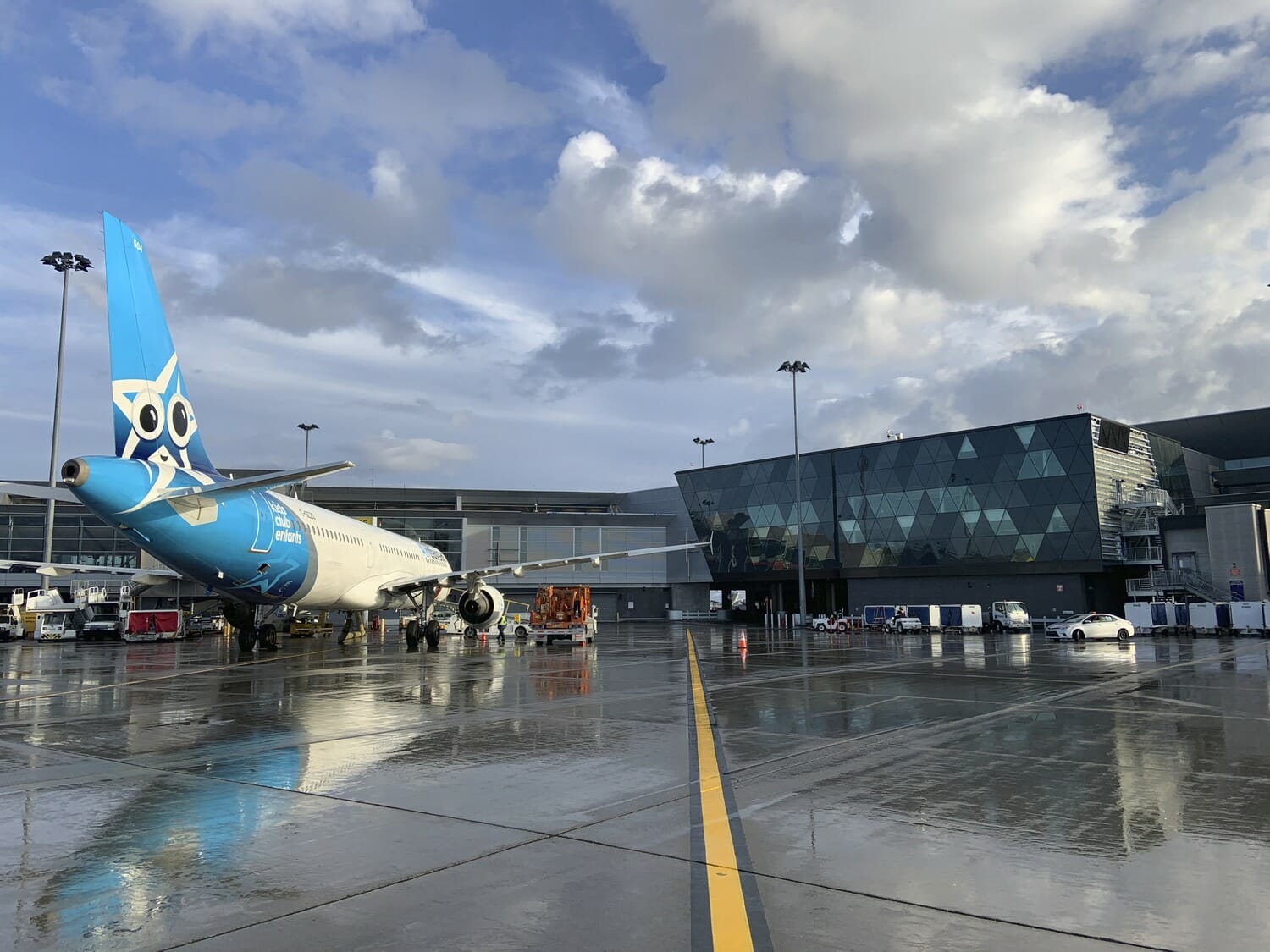 A blue and white airplane parked on the tarmac.