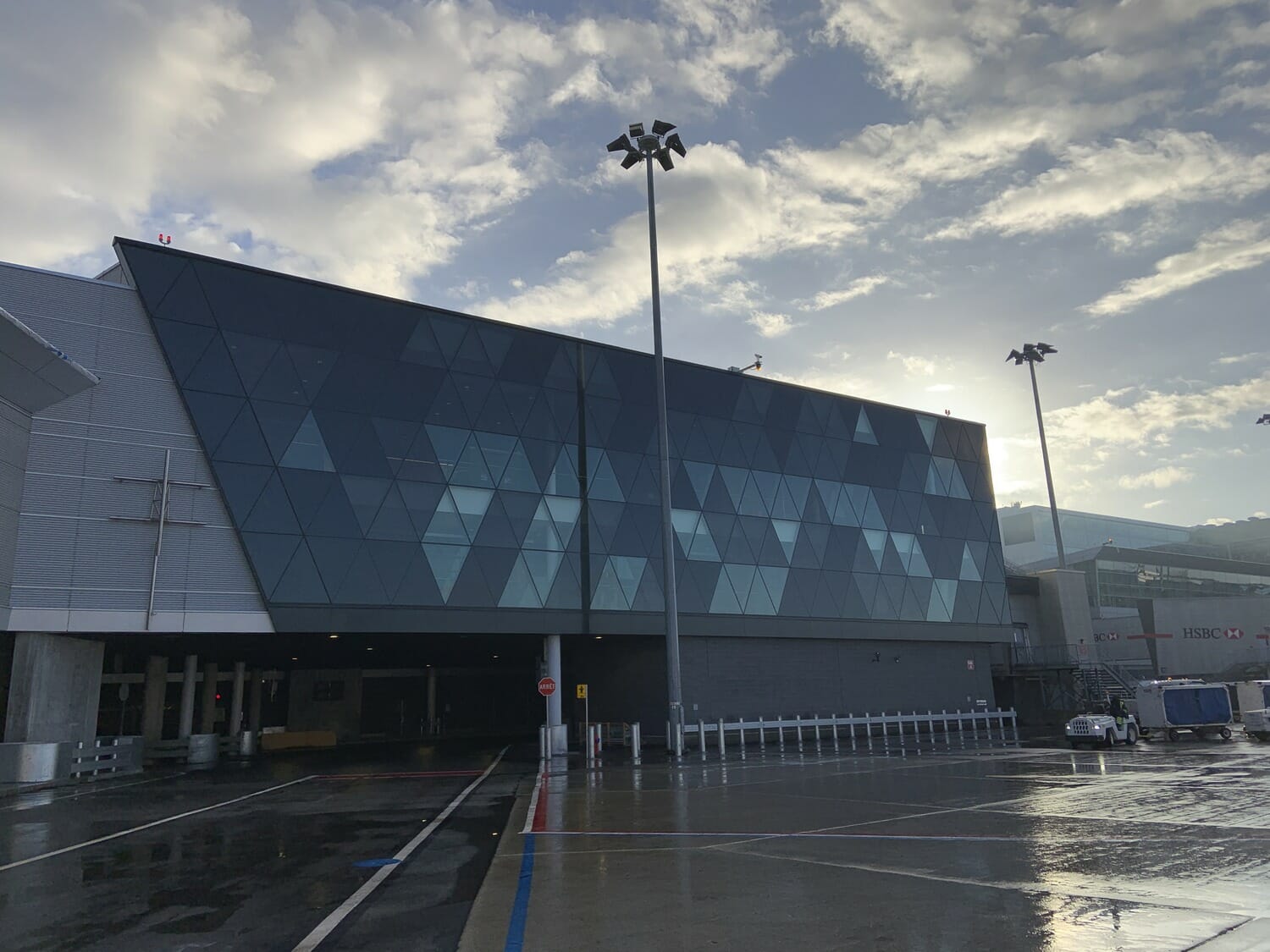 Un aéroport avec un grand bâtiment et un ciel nuageux.