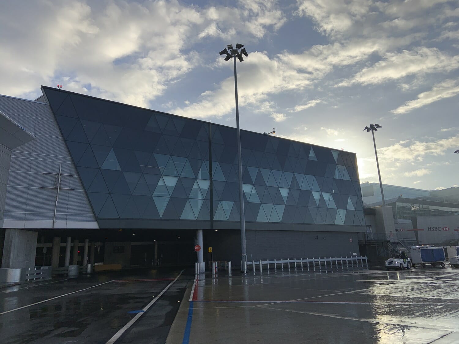 An airport with a large building and a cloudy sky.